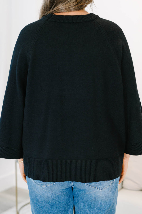 Plus Size black oversized knit sweater with a crew neckline and wide three-quarter length sleeves.
