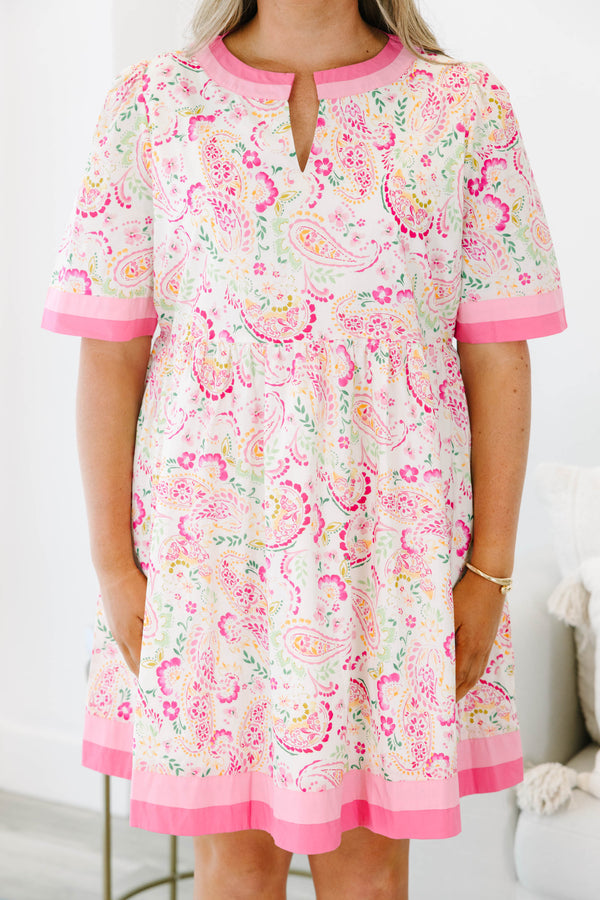 Plus size pink paisley mini dress with a flowy fit, short sleeves, and pink trim details.