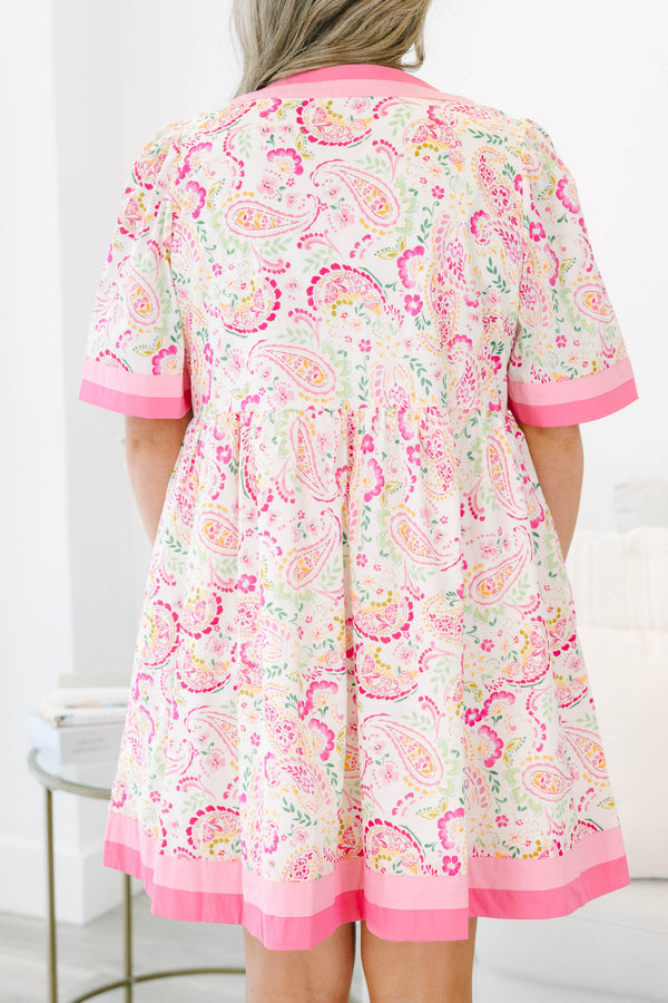 Plus size pink paisley mini dress with a flowy fit, short sleeves, and pink trim details.