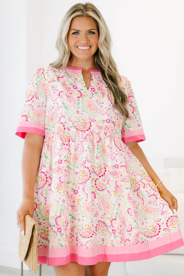 Plus size pink paisley mini dress with a flowy fit, short sleeves, and pink trim details.