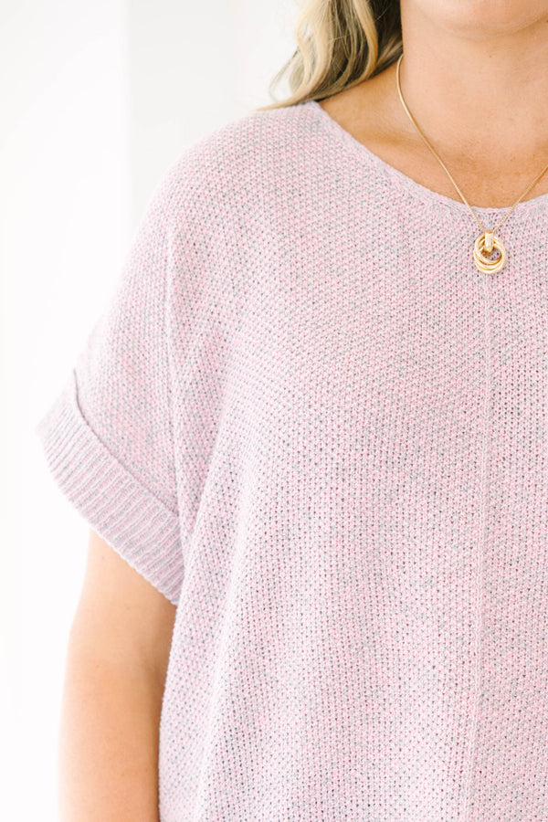 Plus size woman in a pink and gray marled knit short sleeve sweater with a relaxed, flowy fit.