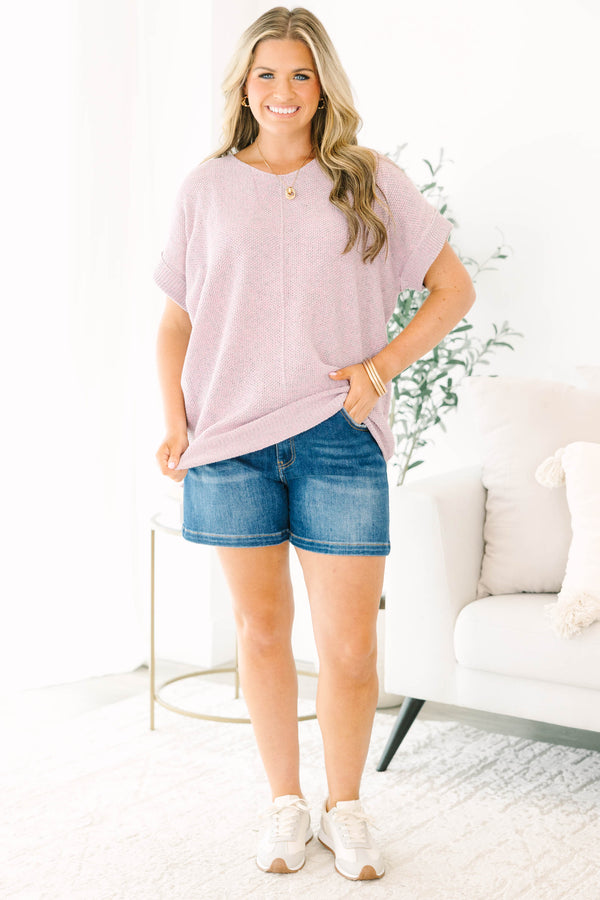 Plus size woman in a pink and gray marled knit short sleeve sweater with a relaxed, flowy fit.