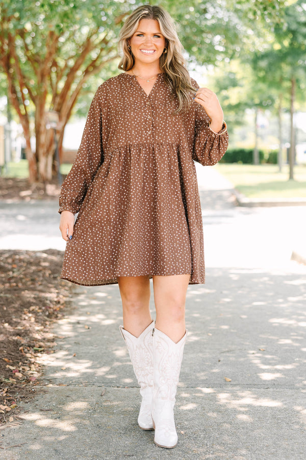 Plus Size brown long-sleeve mini dress with a white floral print, buttoned V-neck, and pockets.