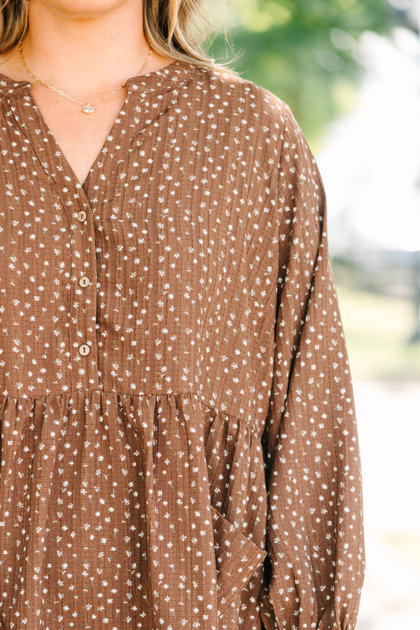 Plus Size brown long-sleeve mini dress with a white floral print, buttoned V-neck, and pockets.