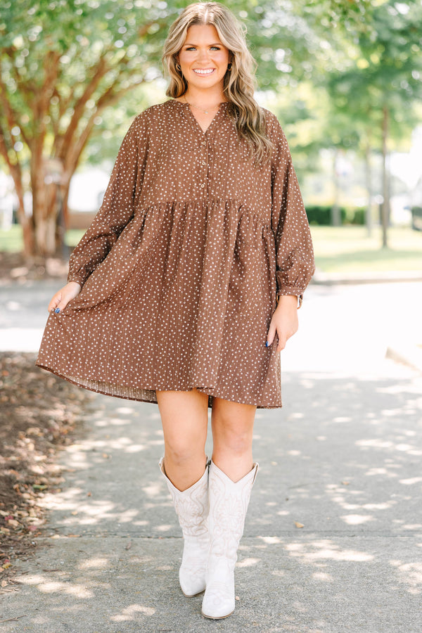 Plus Size brown long-sleeve mini dress with a white floral print, buttoned V-neck, and pockets.