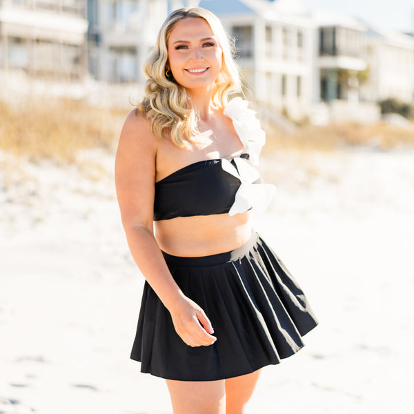 Plus Size black pleated swim skirt with a wide waistband and built-in bottoms.