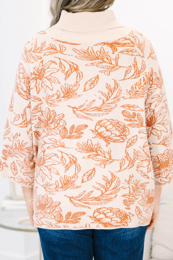 Plus size cream turtleneck sweater with orange floral print, flowy fit, and wide sleeves.