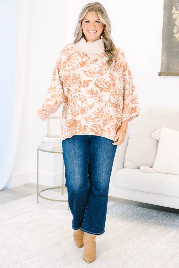 Plus size cream turtleneck sweater with orange floral print, flowy fit, and wide sleeves.