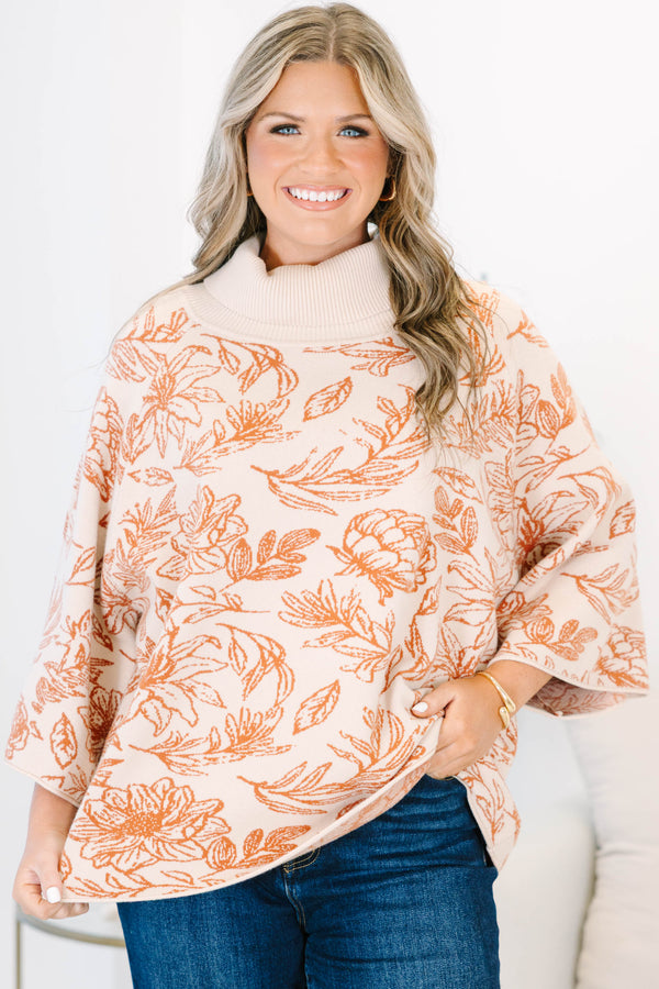 Plus size cream turtleneck sweater with orange floral print, flowy fit, and wide sleeves.