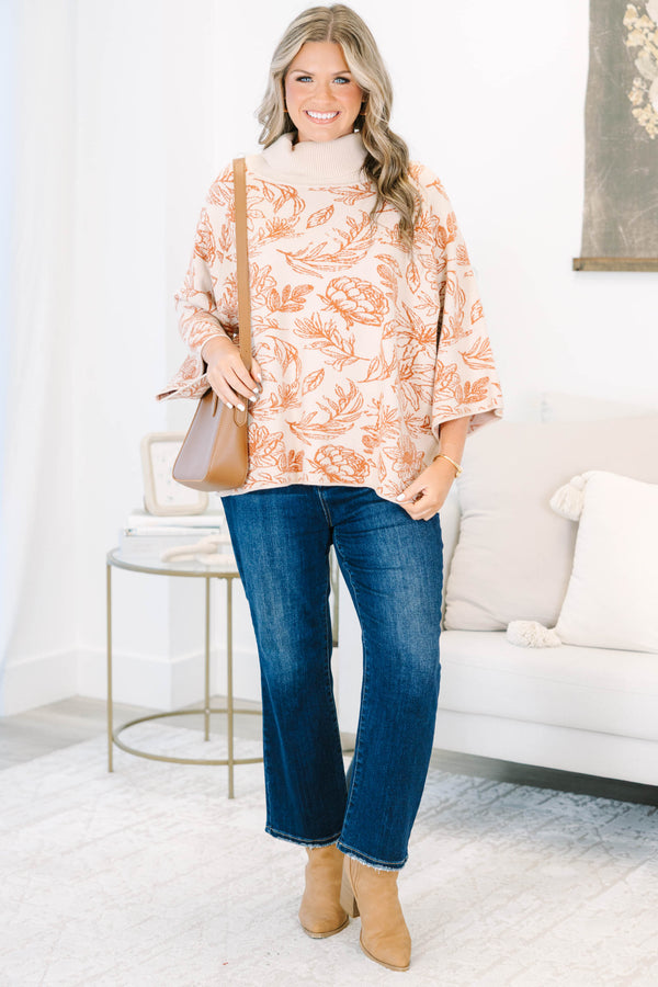 Plus size cream turtleneck sweater with orange floral print, flowy fit, and wide sleeves.