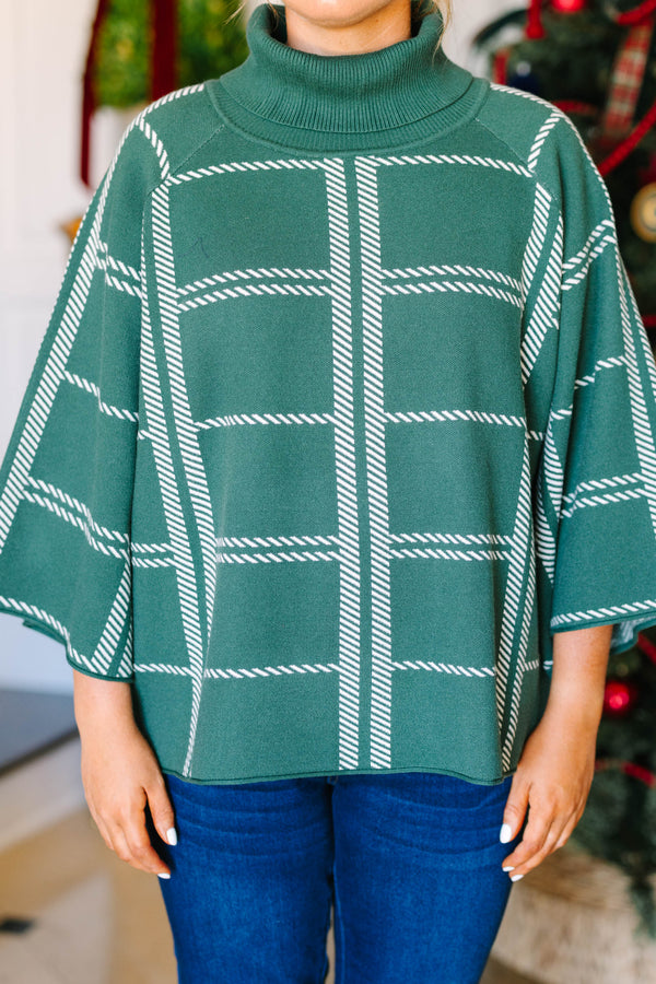 Plus size green turtleneck sweater with a white grid pattern and flowy, wide sleeves.