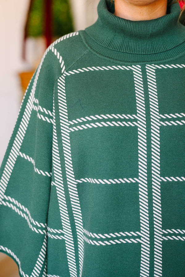 Plus size green turtleneck sweater with a white grid pattern and flowy, wide sleeves.