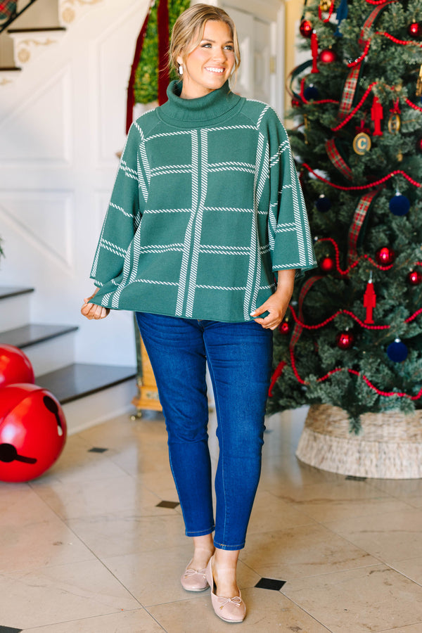 Plus size green turtleneck sweater with a white grid pattern and flowy, wide sleeves.