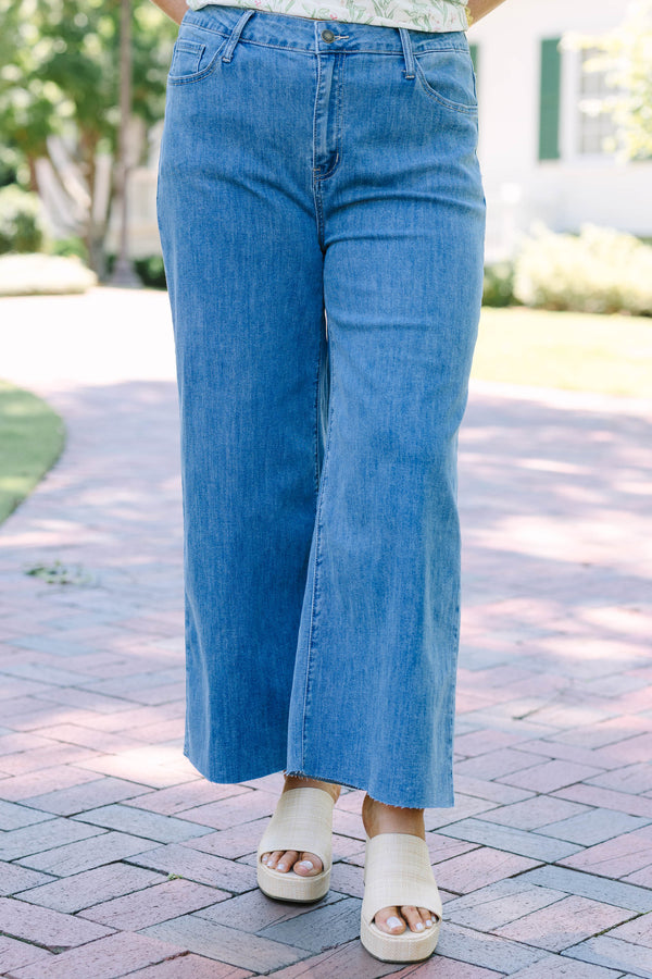 Plus Size light wash wide leg jeans with a raw hem and classic five-pocket styling.