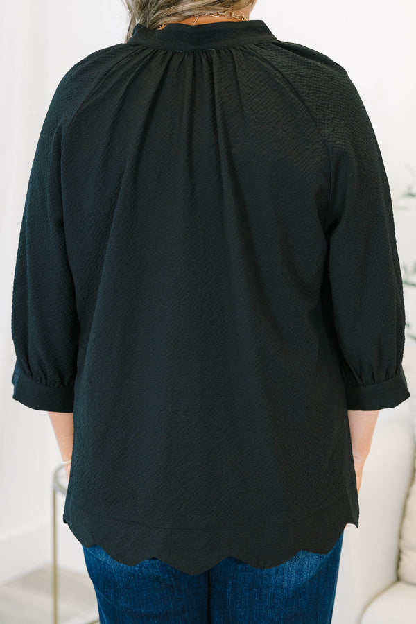 Plus size black top with a flowy fit, V-neckline, and textured polyester fabric.