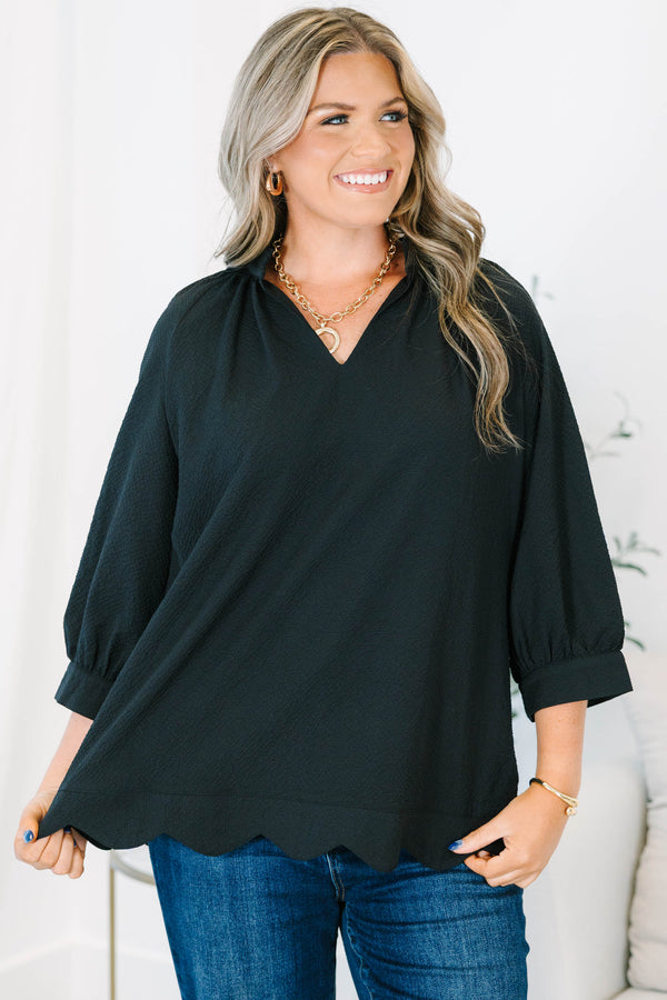 Plus size black top with a flowy fit, V-neckline, and textured polyester fabric.