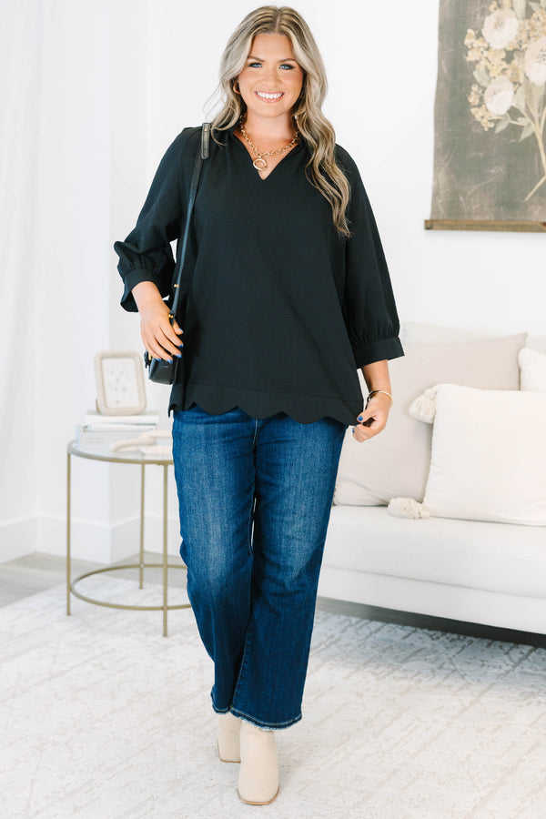 Plus size black top with a flowy fit, V-neckline, and textured polyester fabric.