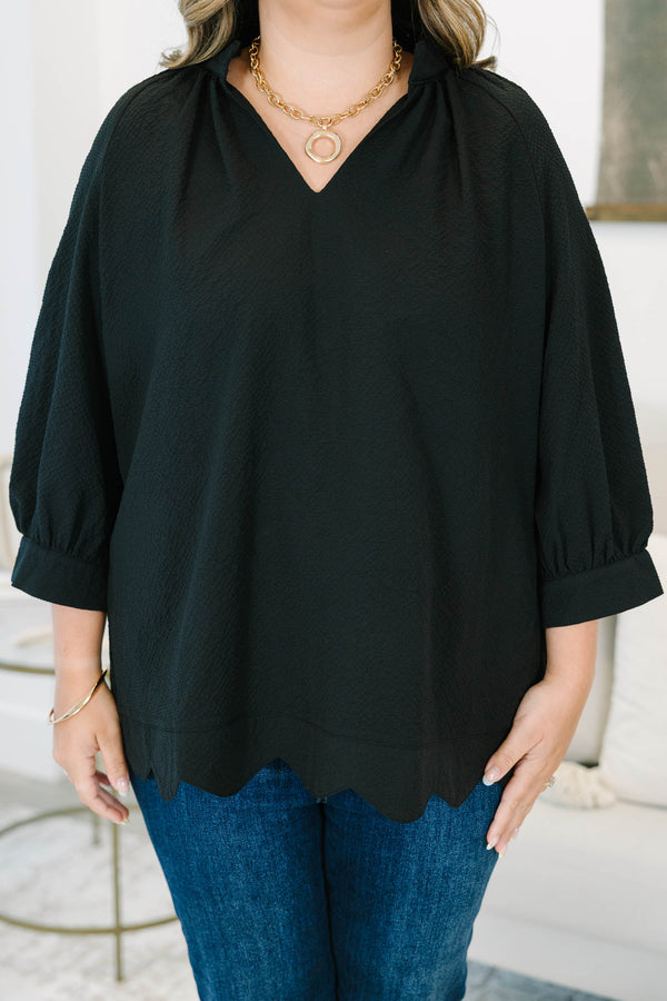 Plus size black top with a flowy fit, V-neckline, and textured polyester fabric.