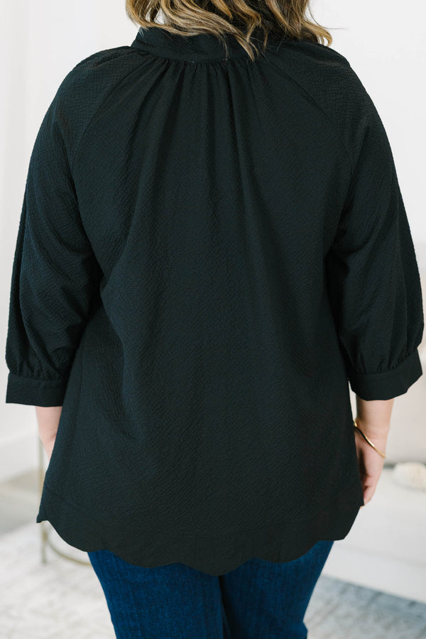 Plus size black top with a flowy fit, V-neckline, and textured polyester fabric.