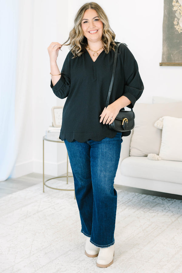 Plus size black top with a flowy fit, V-neckline, and textured polyester fabric.