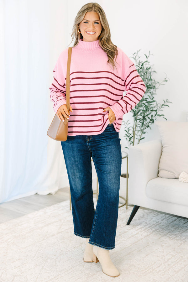 Plus size pink rollneck sweater with burgundy horizontal stripes and a relaxed, flowy fit.