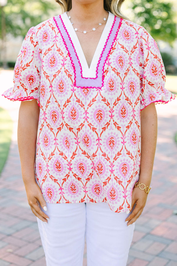 Plus Size pink and white patterned tunic top with a V-neckline and short flutter sleeves.