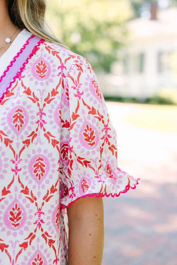 Plus Size pink and white patterned tunic top with a V-neckline and short flutter sleeves.
