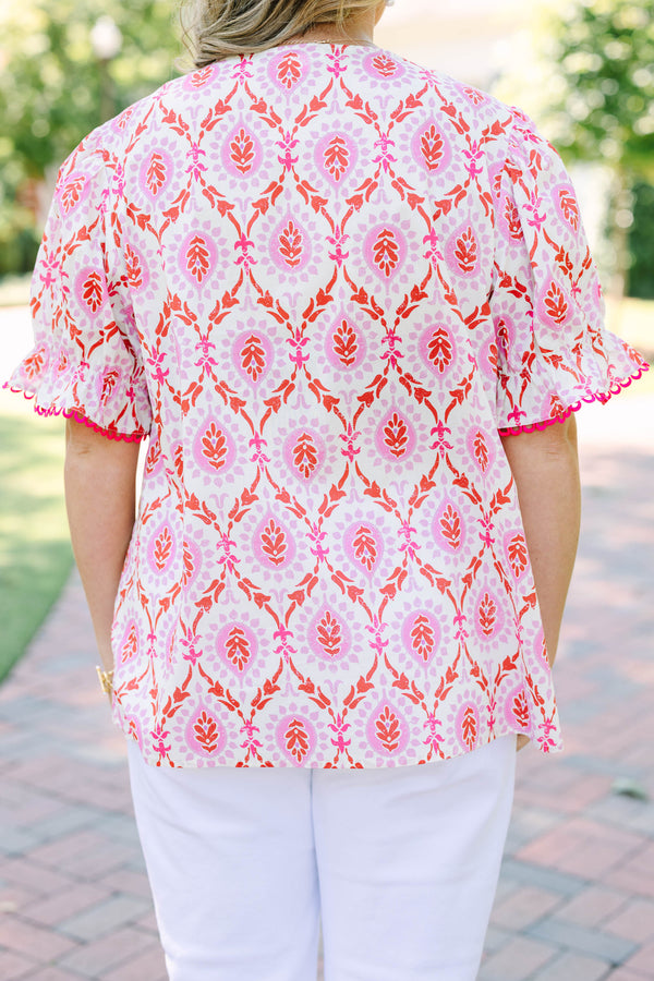 Plus Size pink and white patterned tunic top with a V-neckline and short flutter sleeves.