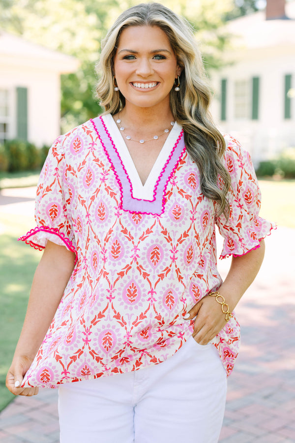 Plus Size pink and white patterned tunic top with a V-neckline and short flutter sleeves.