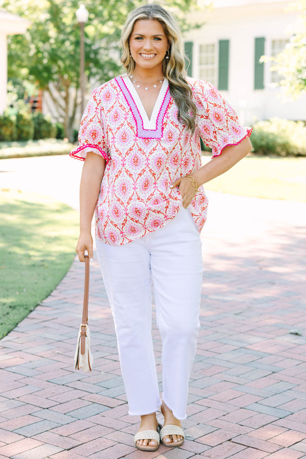 Plus Size pink and white patterned tunic top with a V-neckline and short flutter sleeves.