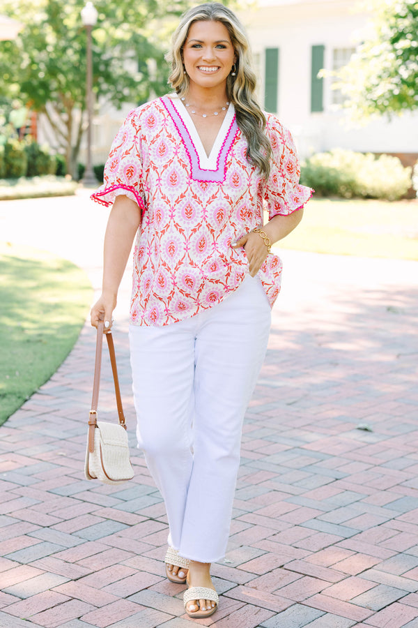 Plus Size pink and white patterned tunic top with a V-neckline and short flutter sleeves.