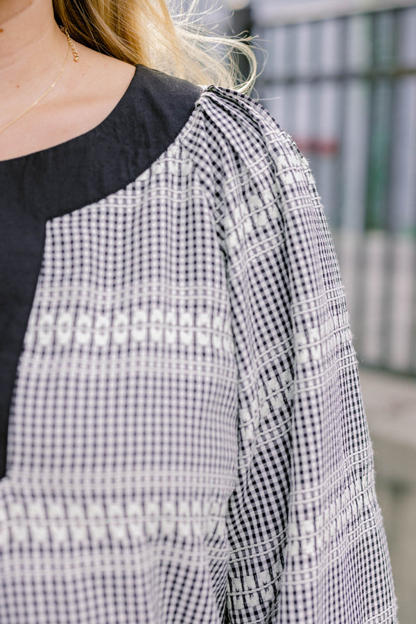 Chic Soul plus size clothing, black plaid top with long flowy sleeves and a thick black detail going along the v-neckline 