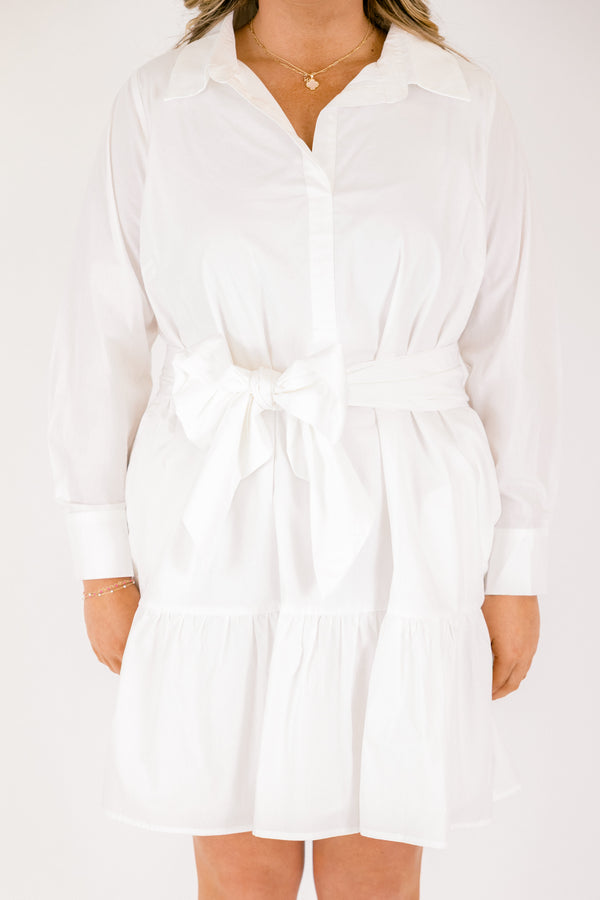 Chic Soul plus size clothing,  white dress with long sleeves a ruffle detail on the bottom of the dress buttons going down to the bottom of the chest and a belt that ties into a bow going around the waist 