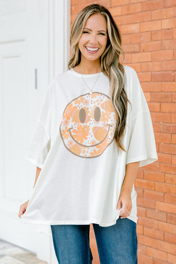 Chic Soul Plus size Clothing, Ivory Short Sleeve tee with a black smiley face on the center of the shirt that is filled with an orange floral design 

