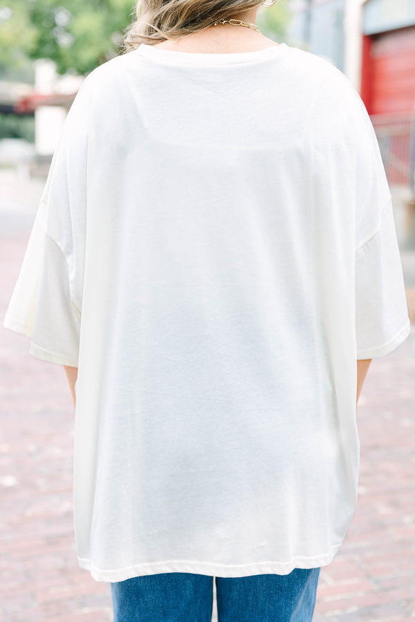 Woman wearing an ivory Girly Ghost Boyfriend Tee with a large pink bow and ghost print.