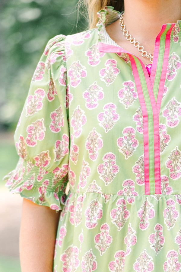Plus Size green floral mini dress with pink trim, V-neckline, and short puff sleeves.