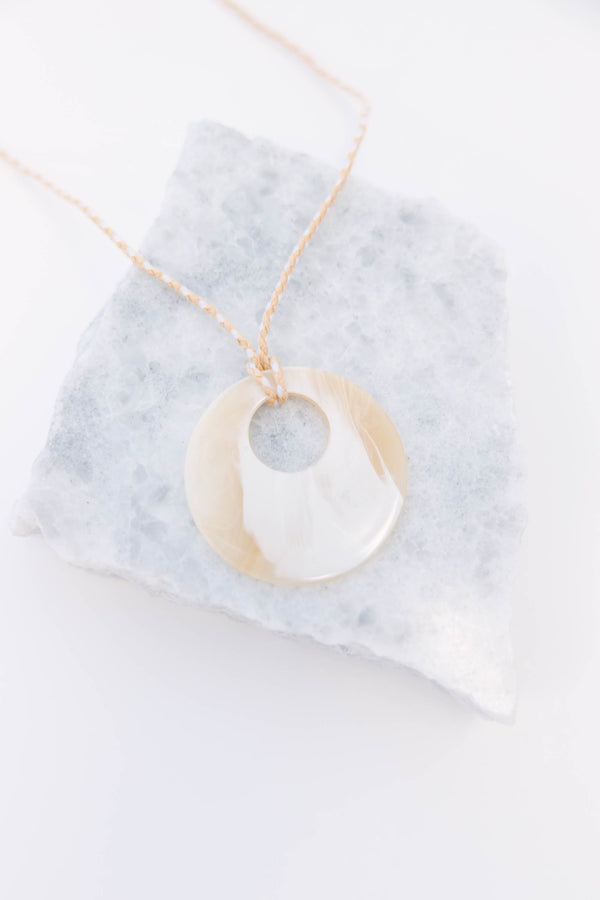Plus Size natural marbled resin circle pendant on a tan braided cord necklace.