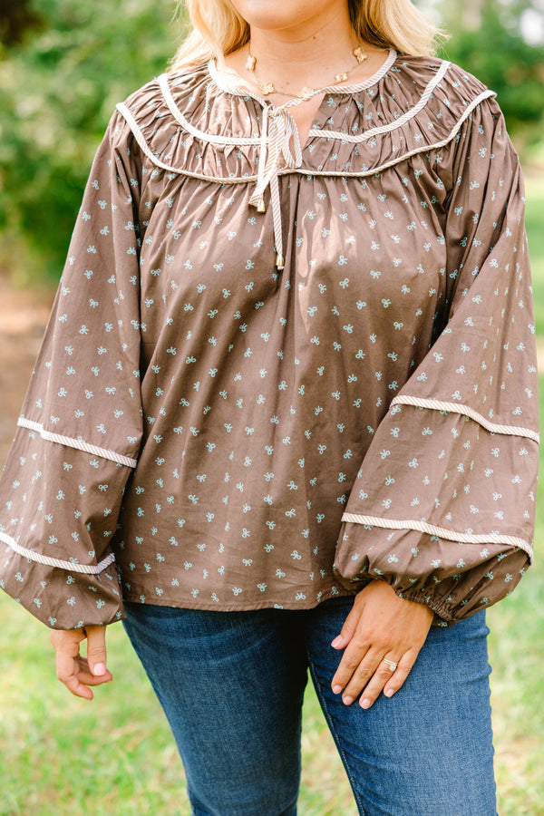 Chic Soul plus size clothing, brown top with long bubble sleeves and a baby blue bow pattern throughout with white stitching details on chest and sleeves 