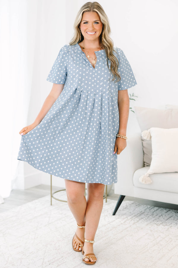 Plus Size blue polka dot dress with short puff sleeves, a V-neckline, and a flowy pleated skirt.