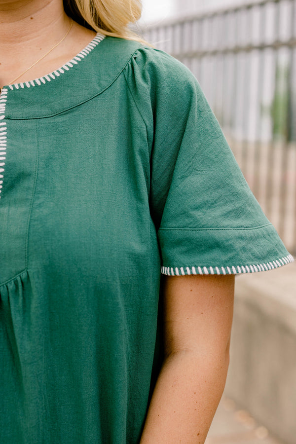 Chic Soul plus size clothing, dark green short bell sleeve knee length flowy dress with subtle v neckline and white stitching detailing around the sleeves and collar 
