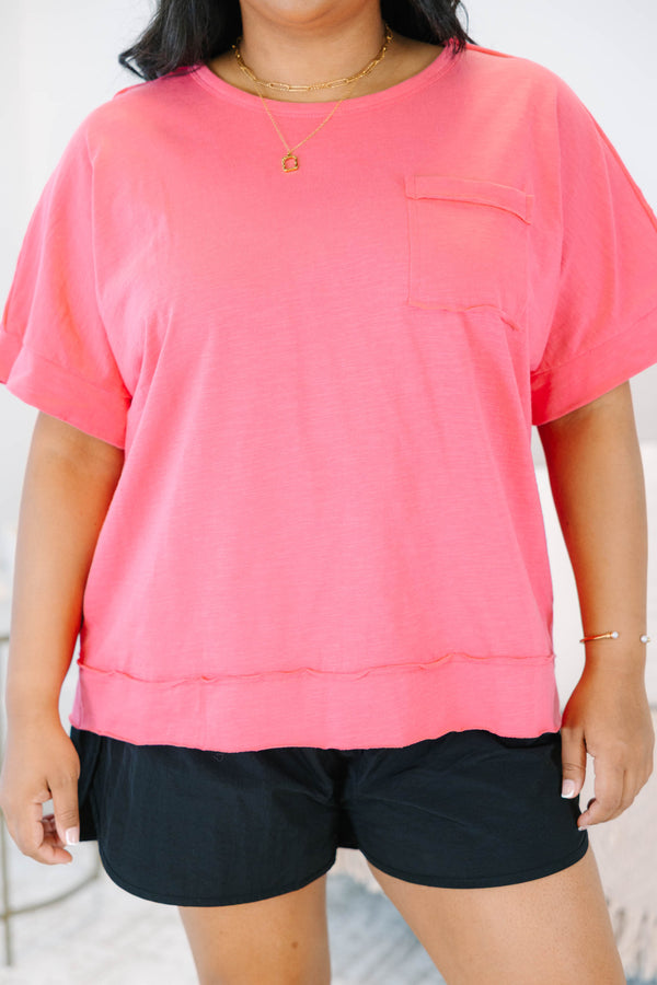 Plus Size pink short sleeve pocket tee with a crew neck and relaxed fit, paired with black shorts.