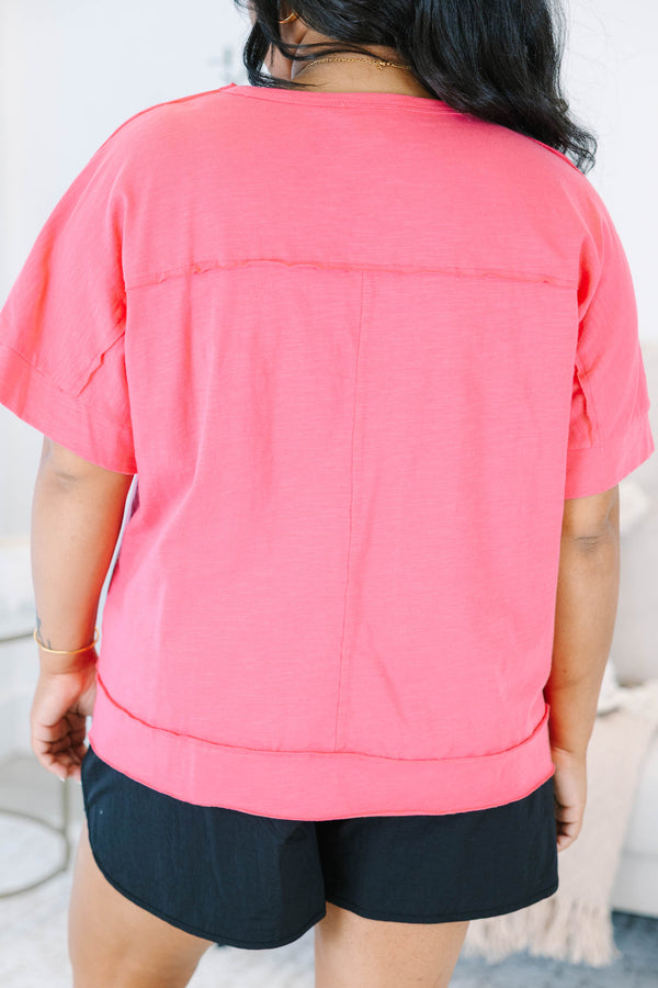 Plus Size pink short sleeve pocket tee with a crew neck and relaxed fit, paired with black shorts.