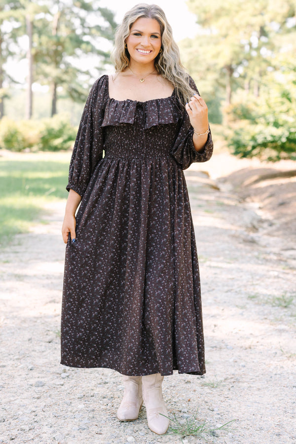 Plus size brown floral midi dress with a smocked waist, ruffled neckline, and flowy long sleeves.