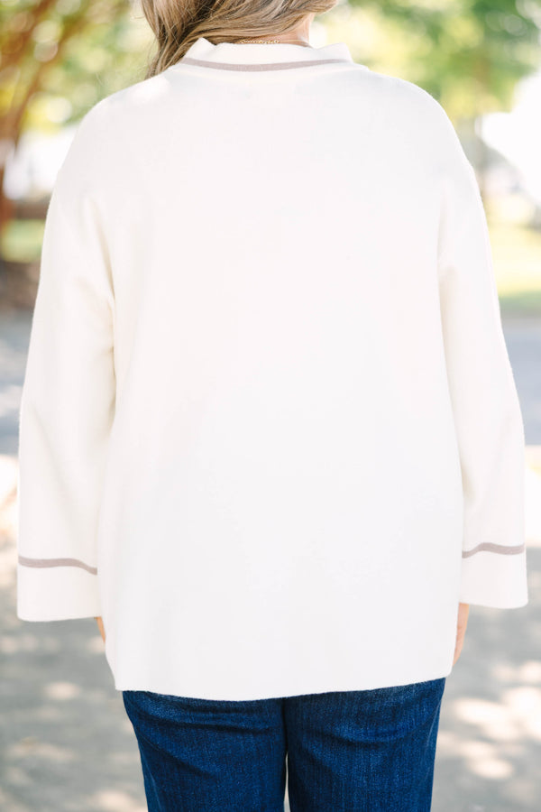 Plus Size ivory oversized sweater with a mock neck, wide sleeves, and tan stripe accents.