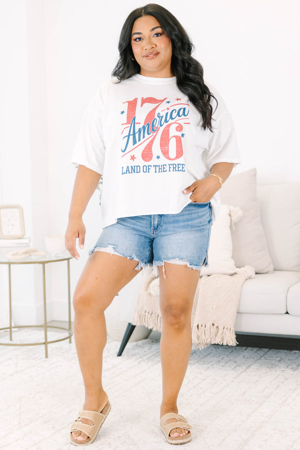 Plus Size white vintage wash graphic tee with 1776 America design and denim shorts.