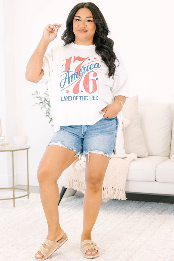 Plus Size white vintage wash graphic tee with 1776 America design and denim shorts.