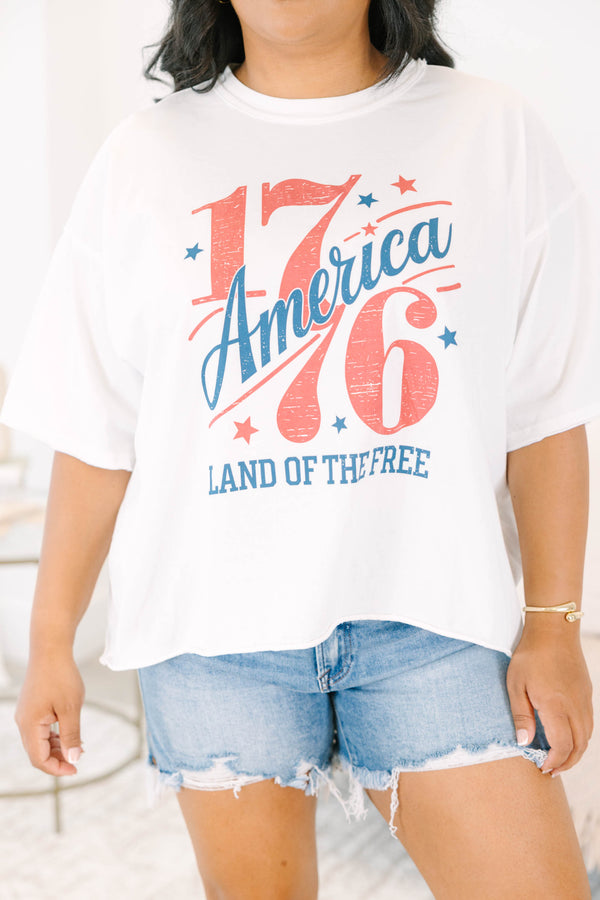 Plus Size white vintage wash graphic tee with 1776 America design and denim shorts.