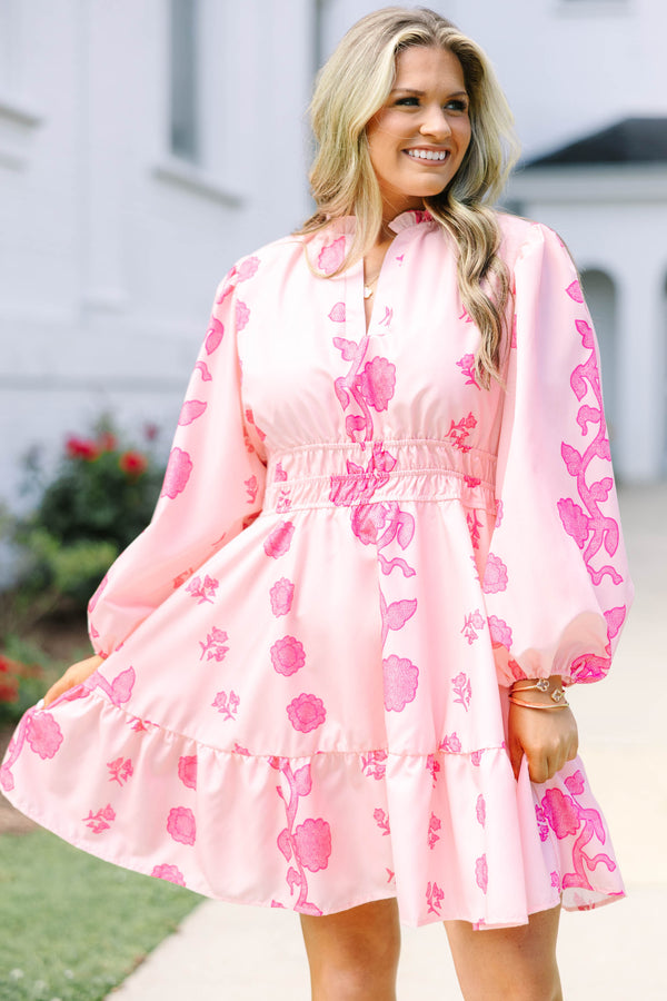Plus Size pink floral mini dress with long puff sleeves, a smocked waist, and a ruffled hem.