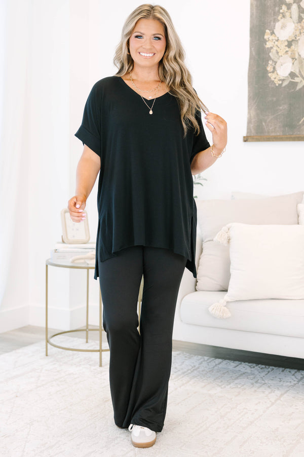 Plus size black flare leggings with a high-waisted, stretchy fit and flowy silhouette.
