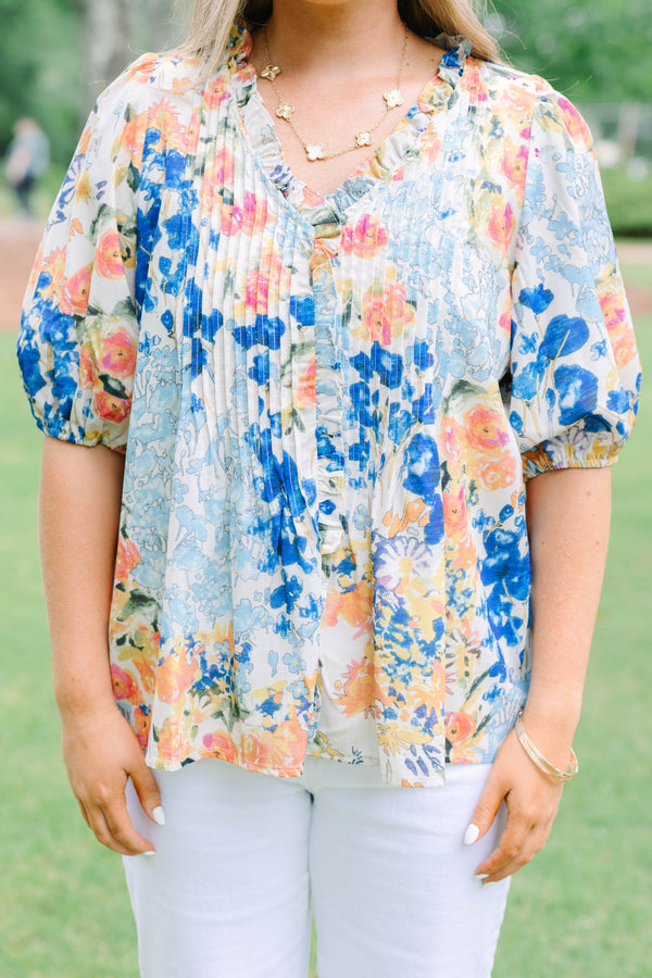 Plus Size floral print top in blue, orange, and yellow with pleated front and puff sleeves.